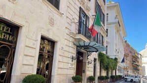 Un hotel storico con una facciata classica, un ingresso imponente e una bandiera.