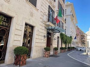 A historic hotel with a classic facade, a prominent entrance, and a flag. - Rome Historic Center, near famed Piazza del Popolo (Rome)