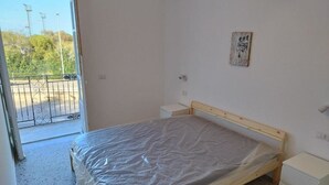A bedroom with a single bed, a bedside table, and a small nightstand.