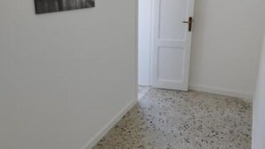 A hallway with a white door and a framed picture on the wall.