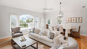 A living room with a sofa, armchairs, a coffee table, and a dining area with a table and chairs.