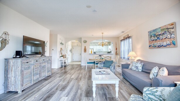 A spacious living area with a modern kitchen, a dining area, and a cozy seating space. - 1521 Ironwood - Barefoot Resort Rentals (North Myrtle Beach)