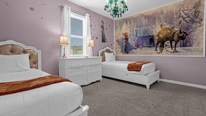 Classic bedroom with two beds, a dresser, and a chandelier.