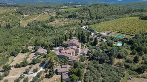 An aerial view of a rural property with multiple buildings, a swimming pool, and vineyard fields. - Caravaggio, Galenda, Gaiole in Chianti, Siena and Chianti (Gaiole in Chianti)