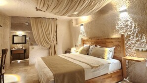 Ein Schlafzimmer mit einem hölzernen Bett, einem Nachttisch, einem Waschtisch und einem Spiegel, sowie ein Badezimmer mit Waschbecken und Spiegel.