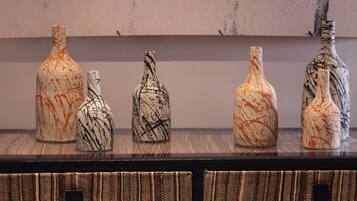 A display of five vases with abstract designs on a shelf.