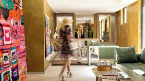 A modern interior with a wooden floor, a green sofa, a coffee table, and a colorful rug. - Palais Ségurane Nice Boutique Hôtel (Nice)