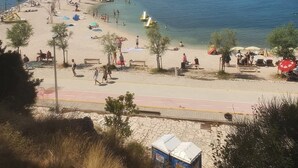 Una spiaggia con cielo sereno, una riva sabbiosa e un mare calmo.