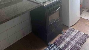 Una cocina compacta con estufa a gas, lavadora y una pequeña encimera.