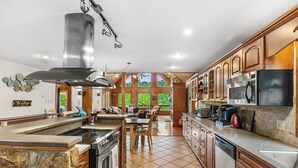 Una cocina con una isla central, estufa, microondas y armarios de madera.