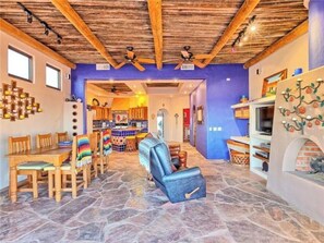 Cozy living area with a high ceiling, dining table, sofa, and fireplace.