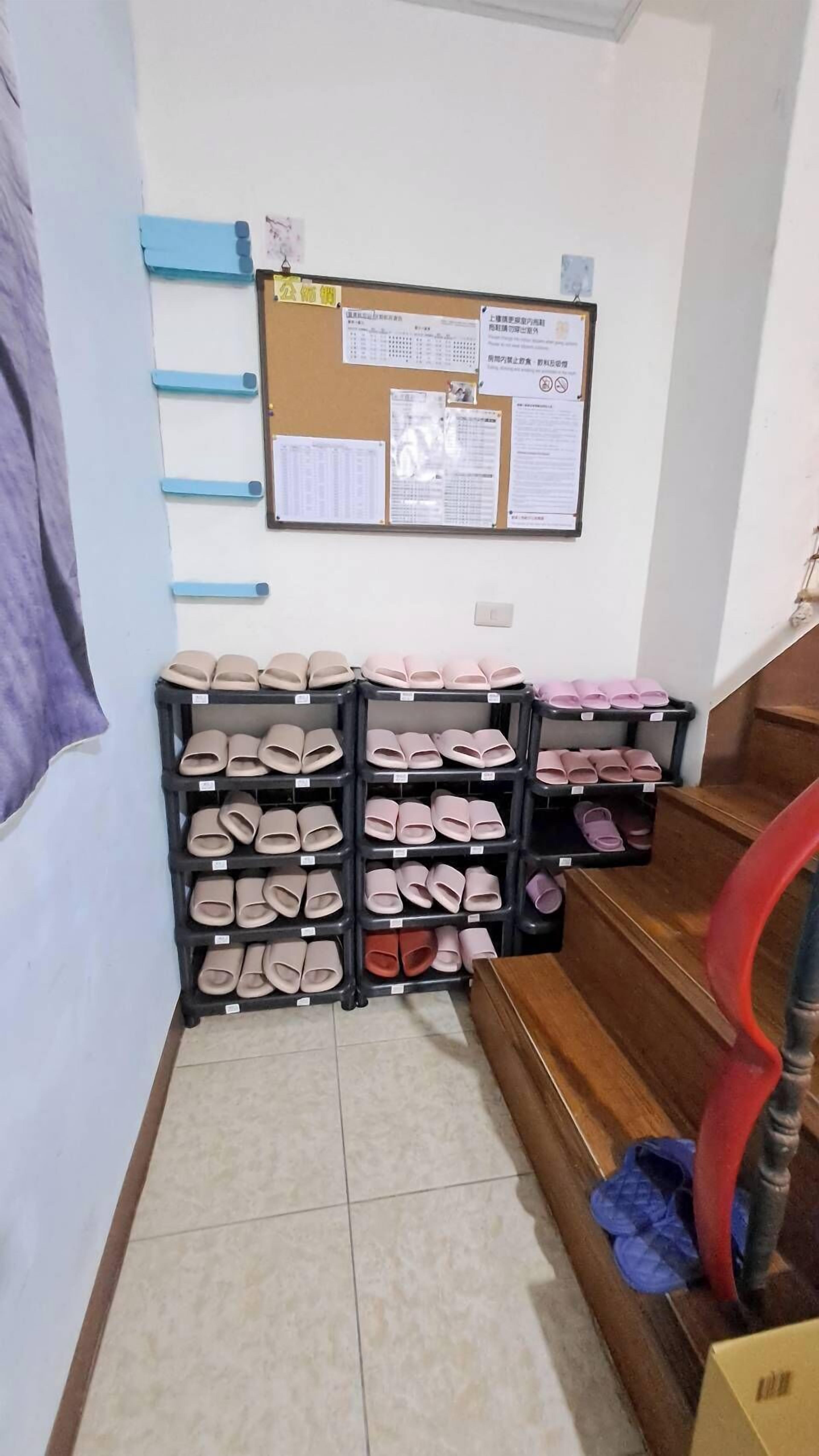 A storage area with shelves of shoes and a bulletin board with notices.
