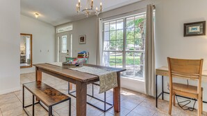 A dining area with a wooden table, benches, and a chandelier. - Pensacola Home w/ Large Yard: 4 Mi to Beach (Pensacola)