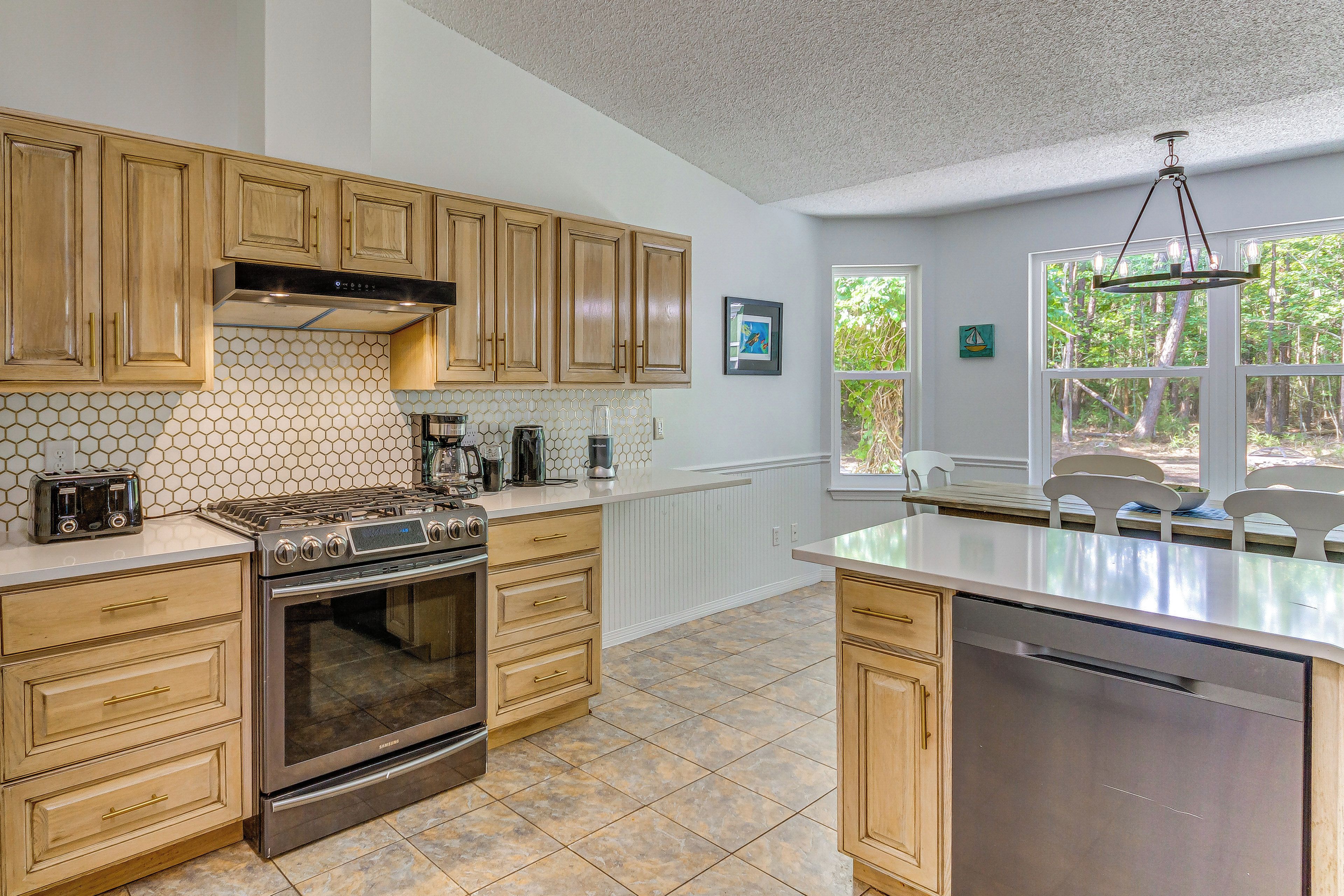 A kitchen with wooden cabinets, a stainless steel stove, and a dishwasher.