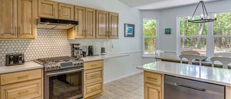 A kitchen with wooden cabinets, a stainless steel stove, and a dishwasher.