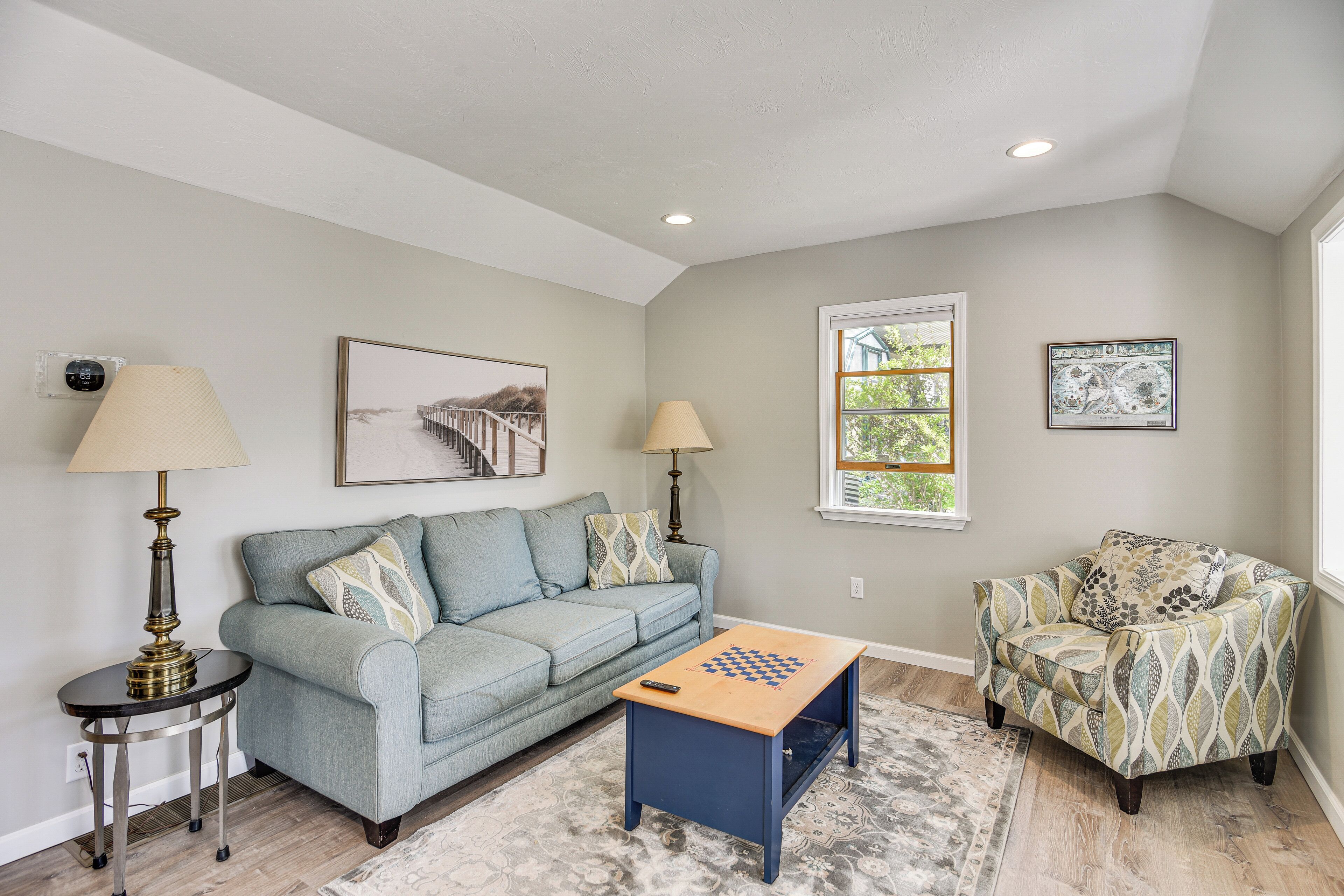 A living room with a sofa, armchairs, a coffee table, and two lamps.