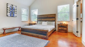 A bedroom with a wooden bed, a bench, a nightstand, and a dresser. - San Marcos Home w/ Fire Pit ~ 10 Mi to Downtown! (San Marcos)