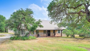 A house with a stone foundation, a metal roof, and a front porch. - San Marcos Home w/ Fire Pit ~ 10 Mi to Downtown! (San Marcos)