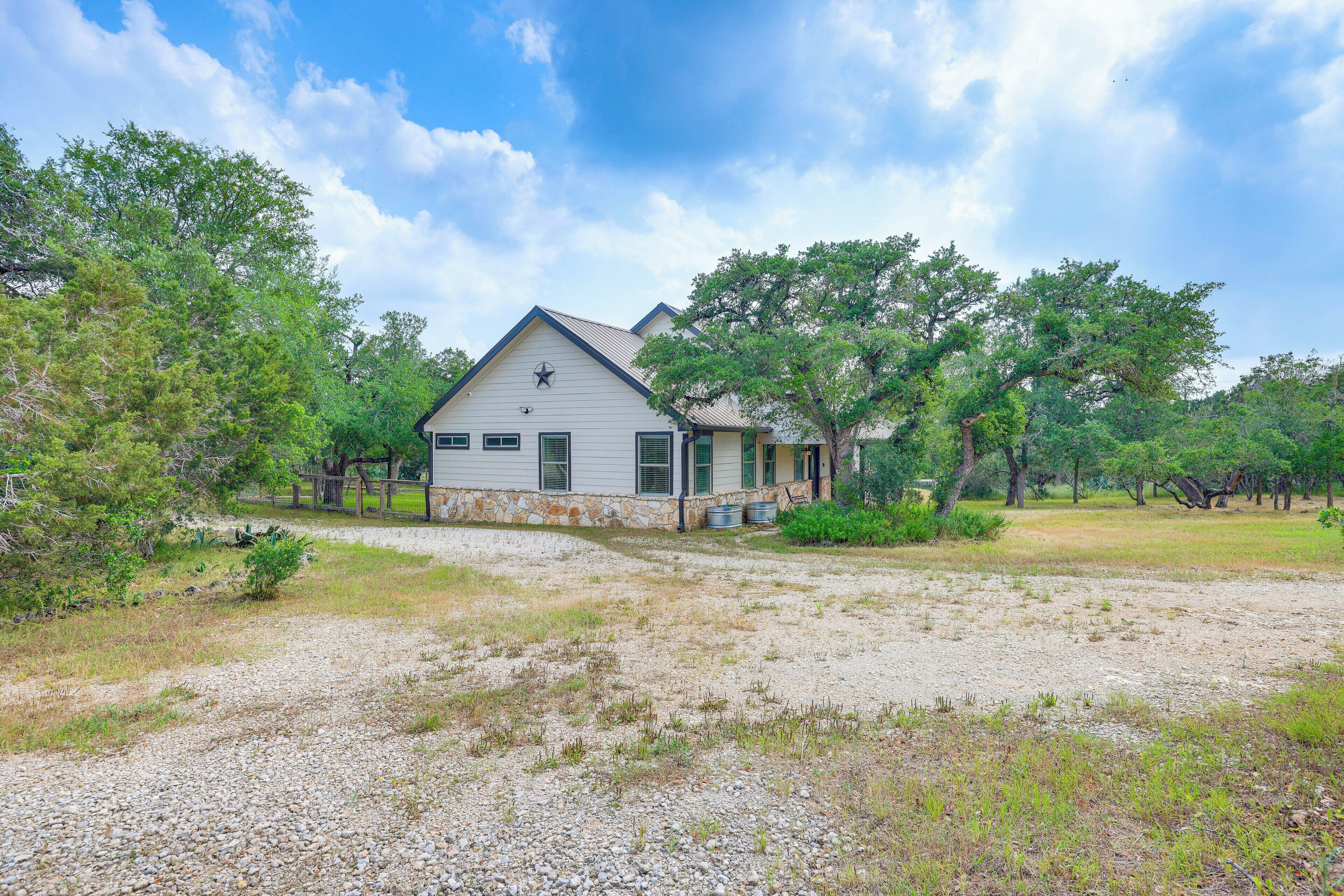 A single-story house with a stone foundation, a front porch, and a clear sky.