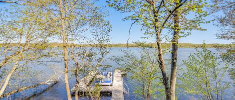 A dock extending into a lake with a boat moored at the end.