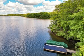 A calm lake with a dock and a boat. - Lakefront Roxboro Home w/ Private Dock! (Roxboro)