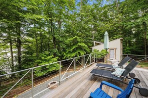 A deck with lounge chairs and a small building, surrounded by trees. - Lakefront Roxboro Home w/ Private Dock! (Roxboro)