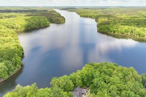 A large body of water surrounded by dense green forest. - Lakefront Roxboro Home w/ Private Dock! (Roxboro)