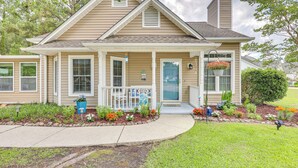 A single-story house with a front porch, a chimney, and a flower bed with various plants and flowers. - Wilmington Family Home: 6 Mi to Wrightsville Beach (Wilmington)