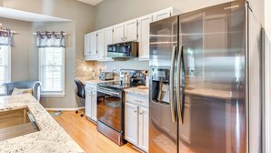 A modern kitchen with stainless steel appliances, white cabinetry, and a granite countertop. - Wilmington Family Home: 6 Mi to Wrightsville Beach (Wilmington)