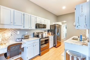 A modern kitchen with white cabinets, stainless steel appliances, and a marble countertop. - Wilmington Family Home: 6 Mi to Wrightsville Beach (Wilmington)