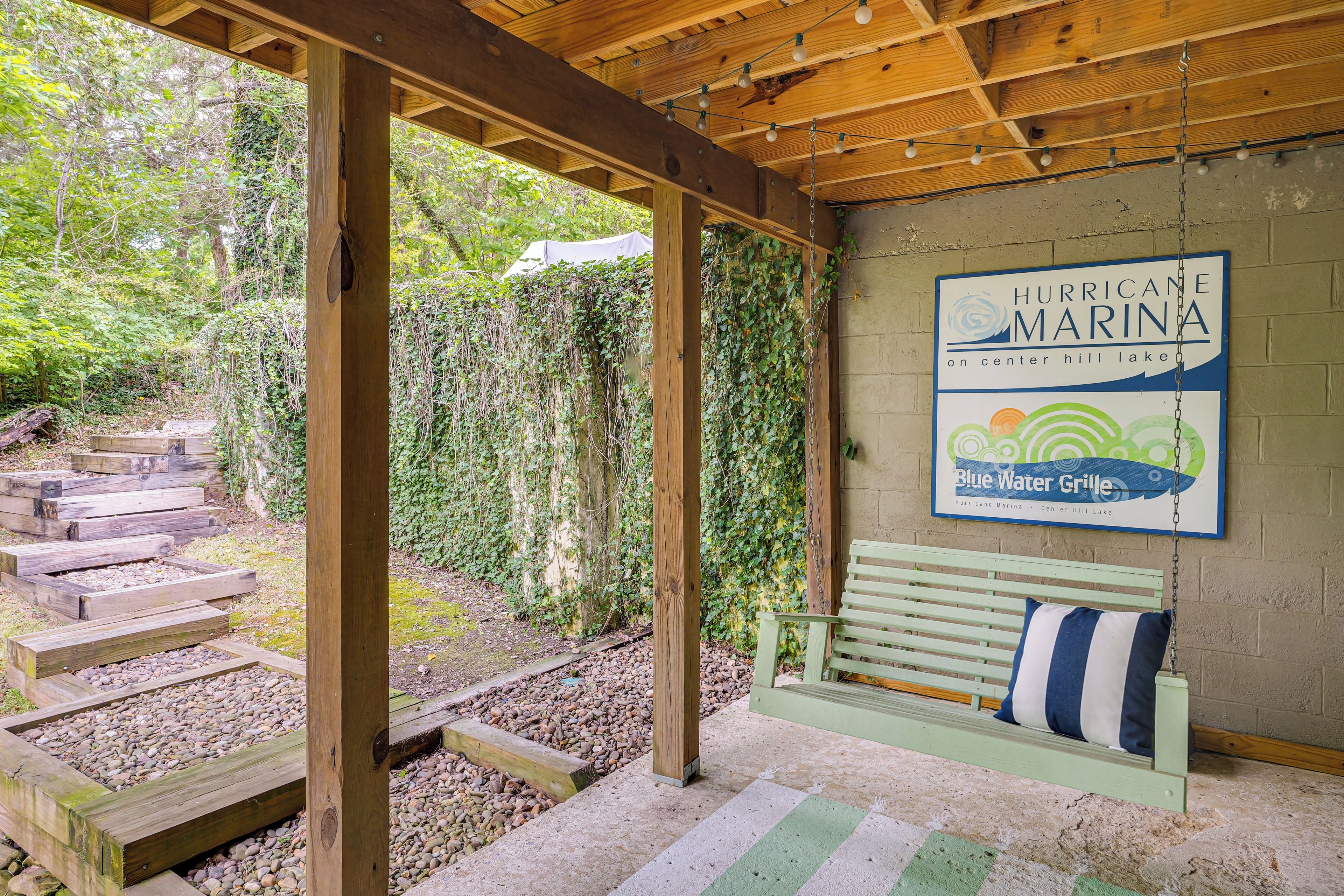 Een houten pergola met een bank en een bordje voor Hurricane Marina aan Center Hill Lake.