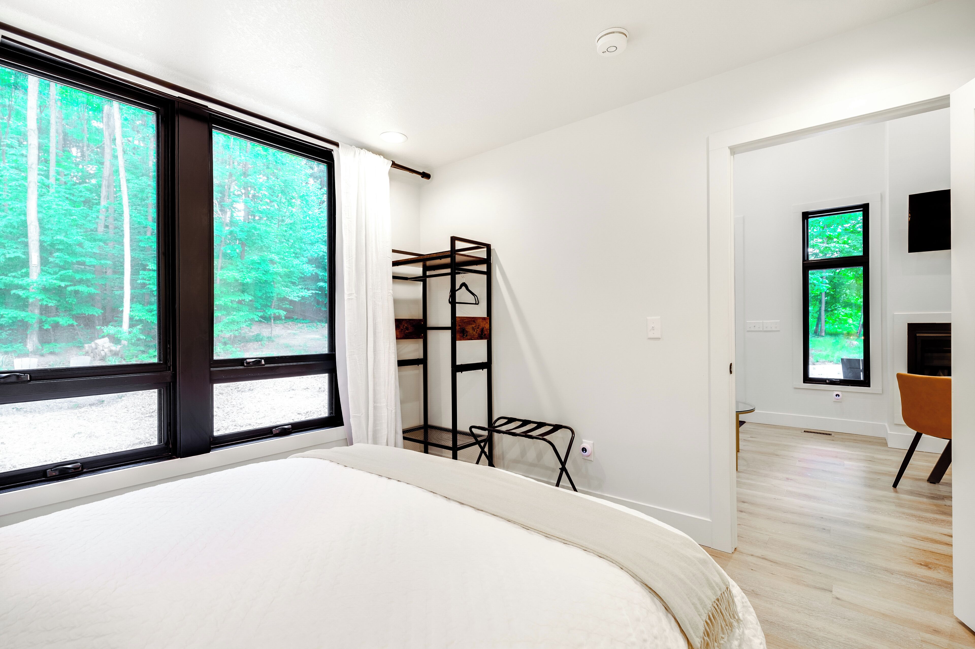 Ein modernes Schlafzimmer mit einem großen Bett, einem Etagenbett und einem Fernseher.