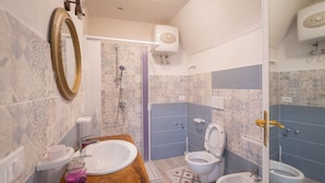 A bathroom with a wooden vanity, a white sink, a toilet, and a bidet. - 3929 Casa Ferrante by Barbarhouse (Vieste)