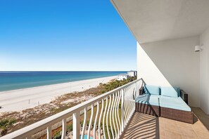Ein Balkon mit Blick auf einen Strand und das Meer.