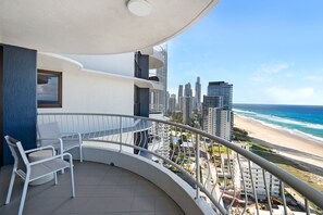 Ein Balkon mit Blick auf einen Strand und hohe Gebäude.