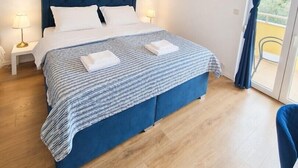 Une chambre à coucher avec un lit, des lampes de chevet, une vue par la fenêtre et un balcon.