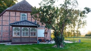 A brick building with a tiled roof, large windows, and a small porch area. - 5 Ferienwohnung in Historischem Alten Gutshaus in Breetz am Fluss (Lenzen (Elbe))