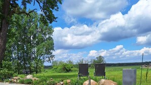 A serene outdoor seating area with stone benches and a paved pathway. - 5 Ferienwohnung in Historischem Alten Gutshaus in Breetz am Fluss (Lenzen (Elbe))