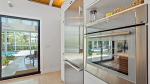 Una cocina moderna con horno empotrado y refrigerador de puerta de vidrio.