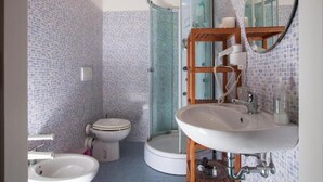 A bathroom with a toilet, a sink, and a shower.