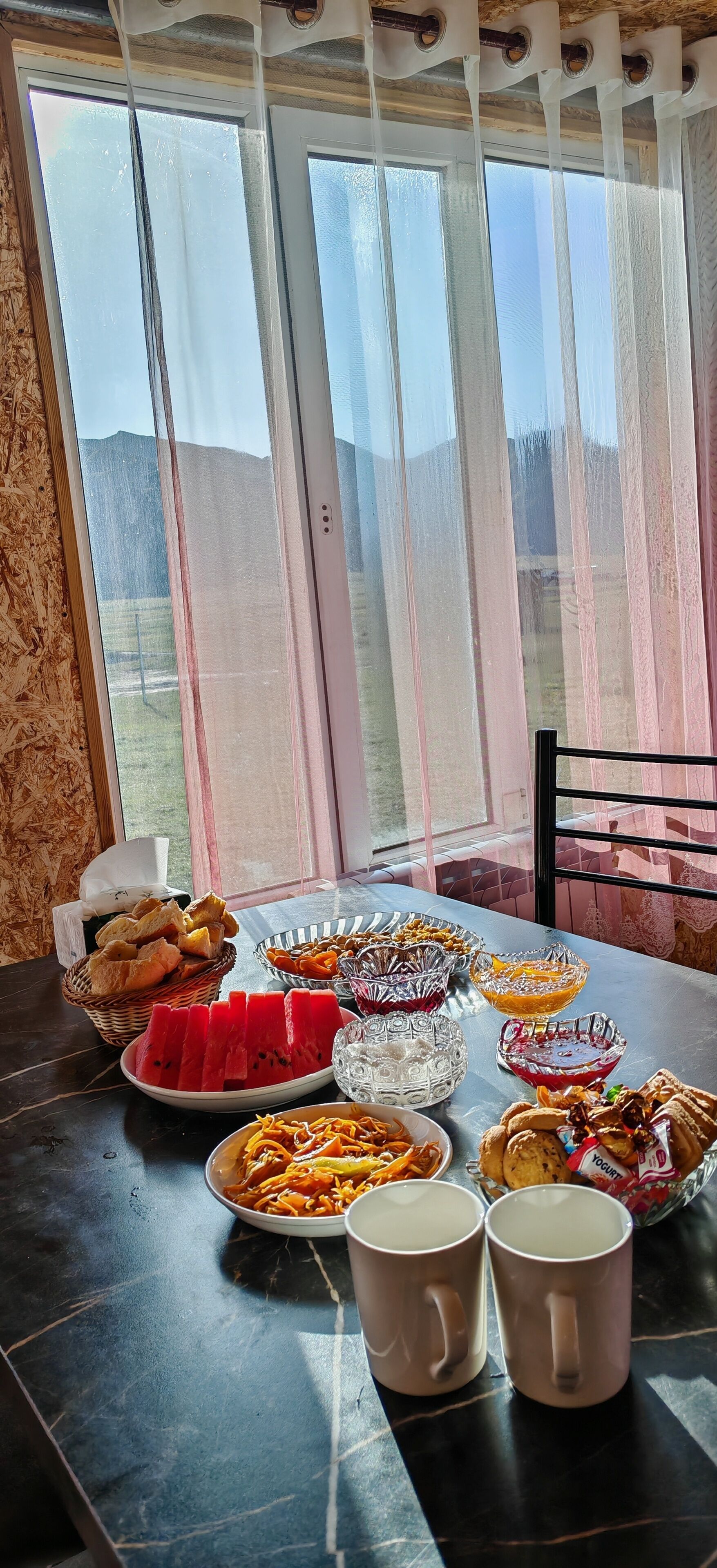 A table with food and drinks, a wicker basket, and a glass bowl.