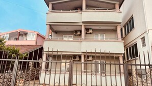 A multi-story building with balconies, air conditioning units, and a gated entrance. - Apartmens Sea House Dobra Voda (Dobre Vode)