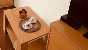 A room with a wooden table, a television, a framed abstract painting, and a cabinet. - Apartmens Sea House Dobra Voda (Dobre Vode)