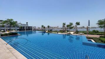 Una piscina al aire libre, una piscina climatizada, sombrillas