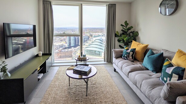 A modern living room with a large window, a flat-screen TV, a sofa with colorful cushions, and a small coffee table. - Charles Hope Manchester Centre (Manchester)