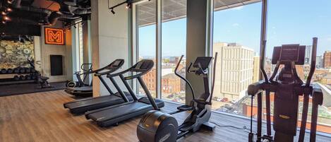 A gym with treadmills, elliptical machines, and a rowing machine.