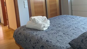 A bedroom with a bed, a wardrobe, and a door. - Apartamento Centro muy Luminoso (Huelva)