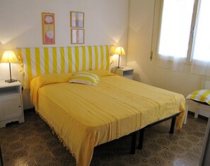Ein Zimmer mit einem Bett, zwei Nachttischen und zwei Lampen.