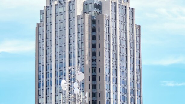 A high-rise building with a distinctive spire and numerous windows. - Downtown Cozy 2 BR Apt - 4min drive MardiGras Park (Mobile)