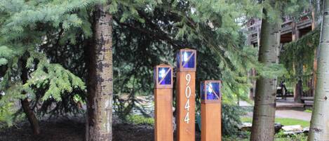 Three wooden posts with numbers 9044, surrounded by trees in a park setting.